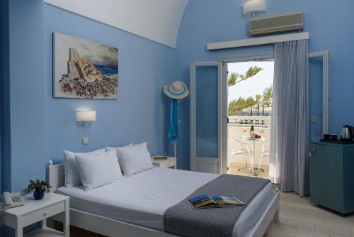 卡马利格拉罗斯酒店的一间蓝色卧室,配有一张床和一个阳台
