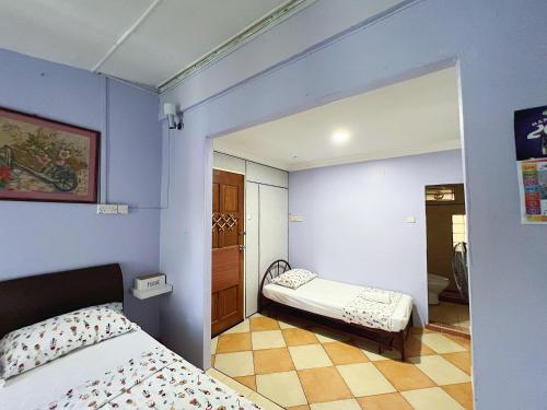 古晋Merdeka Guest House 2的一间拥有蓝色墙壁、一张床和镜子的卧室