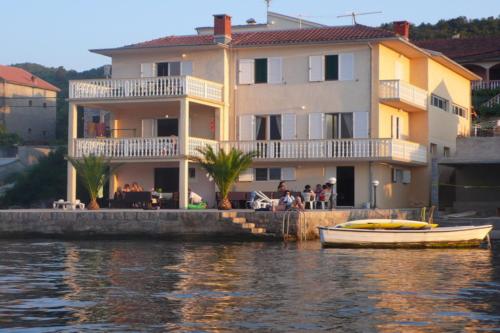 拉多维奇Monténégro, villa dans la baie de Kotor, avec plusieurs appartements tout confort en front de mer!的水面上房子前面的船