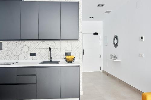 普拉森西亚9 NIDOS Céntrica Suites - Nuevo的厨房配有白色橱柜和水槽