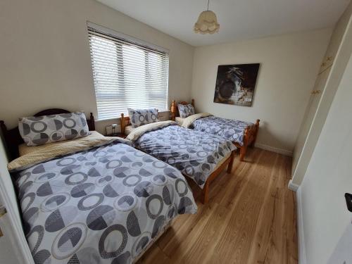 FarnaghtFarnaught Farmhouse Apartment, Lough Rynn, Mohill的一间卧室设有两张床和窗户。