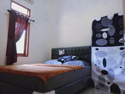 庞岸达兰Griya PAS Pangandaran的一间卧室设有一张床和一个窗口