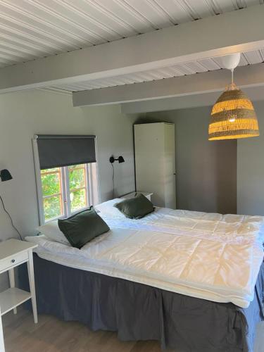 TimmernabbenVilla Löfström的卧室配有一张带两个枕头的大白色床