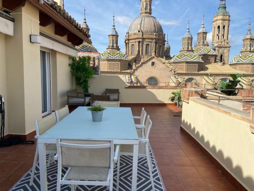 萨拉戈萨Rooftop Alfonso的阳台享有建筑景致,配有桌椅。