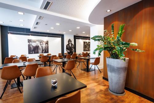 斯图加特国际学生旅馆的一间设有桌椅和盆栽的餐厅