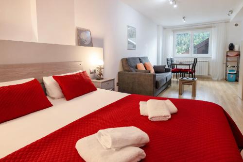 阿林萨尔Studio at Arinsal 100 m away from the slopes with wifi的一间卧室配有一张带红色和白色枕头的大床