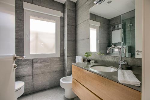 马德里Apartamento Velazquez vistas的一间带水槽和卫生间的浴室以及窗户。