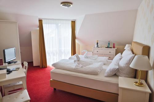 Oranienbaum-Wörlitz沃利茨公园酒店的卧室设有一张白色大床和一扇窗户。