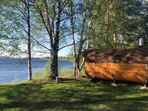 佩洛Napapiirin Eräkartano的木船坐在湖边的草地上