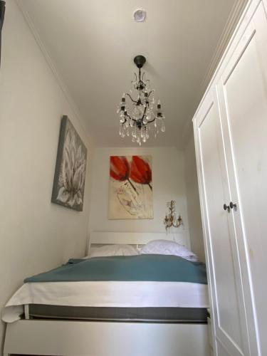 库克斯港Haus Frauenpreiss 67的一间带一张床和吊灯的小卧室