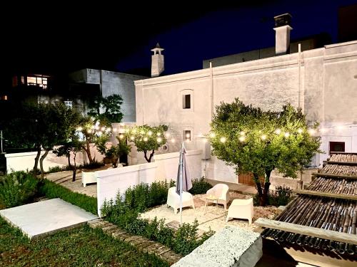 蒙塔尔巴诺Villa Ricciardi-Suite famigliare 1-zona Ostuni的一座带椅子和灯的院子的建筑