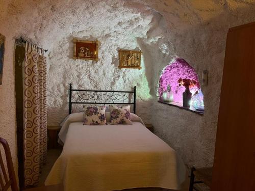 FontanarCasa Cueva La Fuente的卧室配有一张石墙床