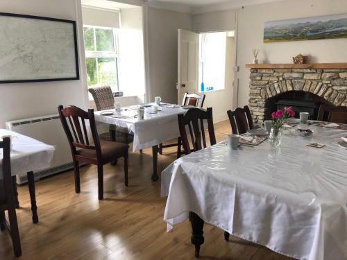 肯梅尔Gortamullen House, Kenmare的一间带2张桌子和壁炉的用餐室