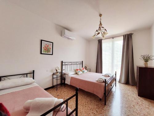佩尔莱多Agriturismo Conca Sandra - Farm Stay on Lake Como的一间卧室设有两张床和窗户。