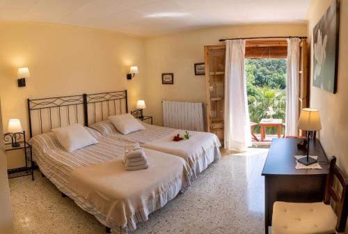 圣苏珊娜坎洛西奇旅馆的一间卧室设有两张床、一张桌子和一个窗口。