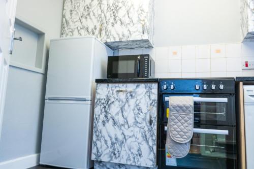曼彻斯特Vanville Homes的厨房配有炉灶和2台冰箱。