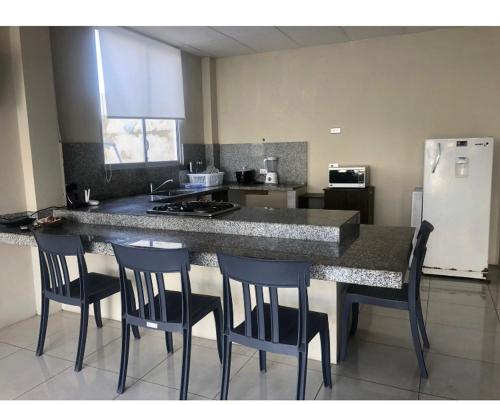 萨利纳斯KsaMarita的厨房配有带椅子的柜台和冰箱。