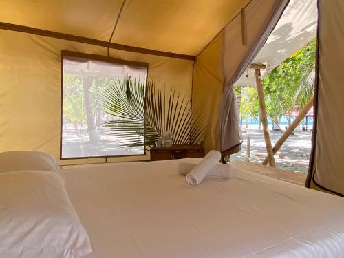 伯里塔卡Manoush Beach的卧室配有白色的床和窗户。