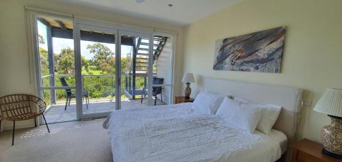 因沃洛什Coastal Soul Villa at Broadbeach的一间带白色床的卧室和一个阳台