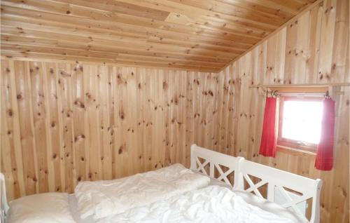 灵厄比灵厄比马萨普拉森二号度假屋的卧室配有木墙内的一张床