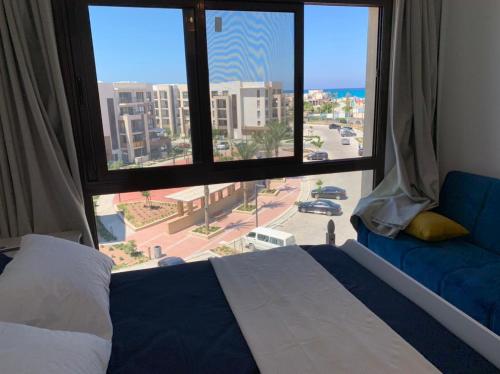 阿莱曼Marassi Marina的卧室设有大窗户,享有城市美景