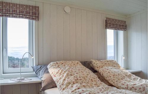 SøndeledCozy Home In Sndeled With House Sea View的一间卧室配有带枕头的床和2个窗户。