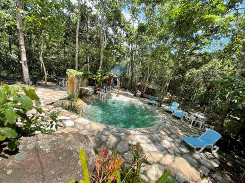 皮雷诺波利斯Recanto dos manacas的庭院内的游泳池,配有椅子和桌子