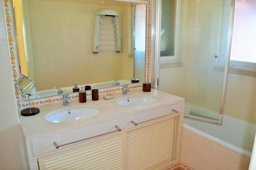 沙尔内卡Apartamento Golf Resort的一间带两个盥洗盆和淋浴的浴室