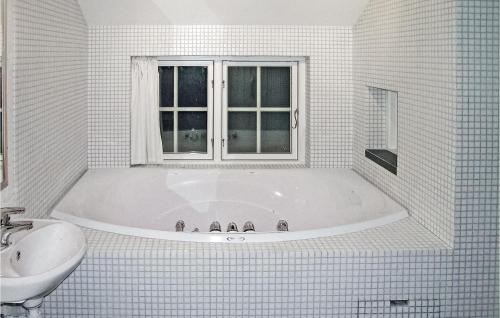 Cozy Home In Gl With Sauna的白色的浴室设有浴缸和水槽。