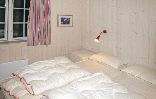 Cozy Home In Gl With Sauna的一张带白色床单的床和一盏灯