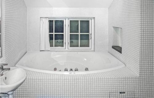 Awesome Home In Gl With Sauna的白色的浴室设有浴缸和水槽。