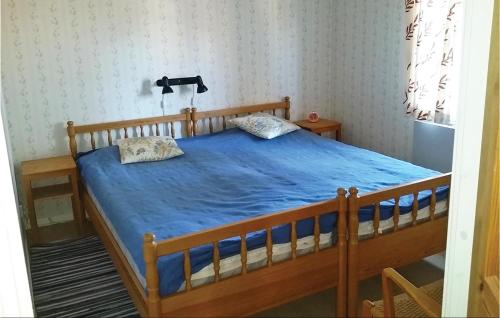 赛纳3 Bedroom Awesome Home In Srna的一间卧室配有一张带蓝色棉被的木床
