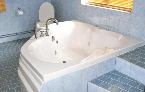Stor-HullsjönStunning Home In Stde With Kitchen的蓝色瓷砖浴室内的白色浴缸