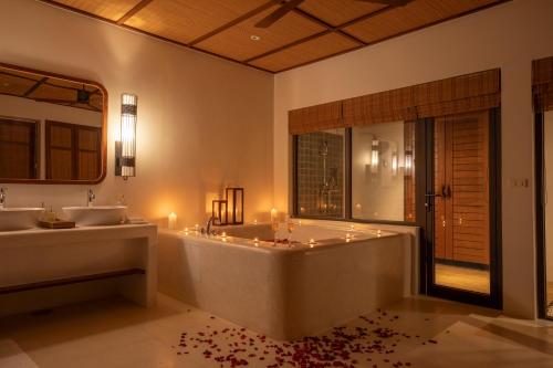 瓜隆岛瓜隆岛皇家金沙酒店的带浴缸、两个盥洗盆和浴缸的浴室。