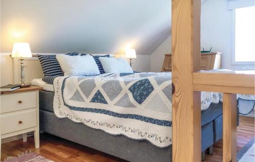 埃斯基尔斯蒂纳Amazing Home In Eskilstuna With 1 Bedrooms, Sauna And Wifi的一间卧室配有一张带蓝色和白色毯子和枕头的床。