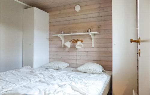 KittelfjällCozy Home In Dikans With Kitchen的卧室配有白色床,墙上设有架子