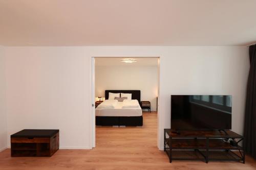 卢塞恩KoBi Apartments Falkenplatz的一间卧室配有一张床和一台大电视