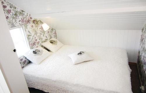 王室港3 Bedroom Beautiful Apartment In Kungshamn的小卧室配有白色的床铺,墙上挂着鲜花