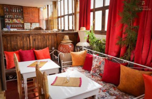 马拉喀什伊尔肯纳利亚酒店的餐厅设有两张桌子和红色窗帘