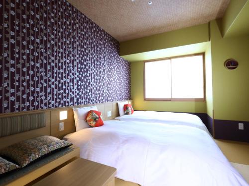 大阪Onyado Nono Osaka Yodoyabashi的卧室设有一张白色大床和一扇窗户。