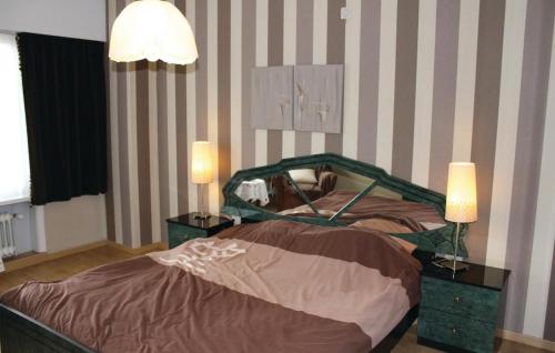 Ruiselede卢塞莱德62号桑拿度假屋的一间卧室配有一张带2个床头柜和2盏灯的床。