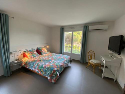 圣拉斐尔VILLA Saint Raphael Valescure Piscine Clim Wifi Golf的一间卧室配有一张床、一张书桌和一个窗户。