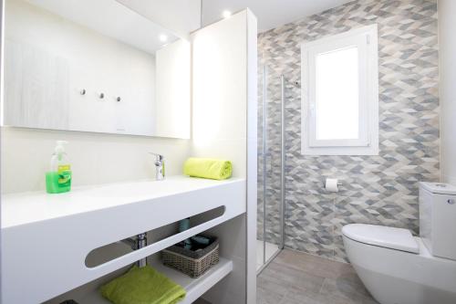 蓬塔格罗萨Villa Vistamar的一间带水槽和卫生间的浴室以及窗户。