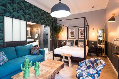巴黎The Royal Elysée Suite的客厅配有蓝色的沙发和床。