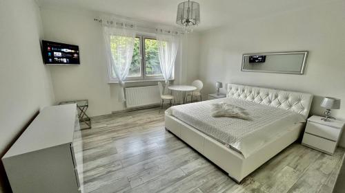 乌斯特卡VILLA MARYNARZA的白色卧室配有床和桌子
