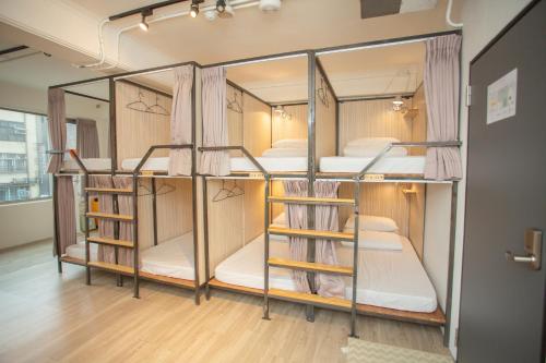 台北小角落 Corner Hostel & Cafe的铺有木地板的客房内配有两张双层床。