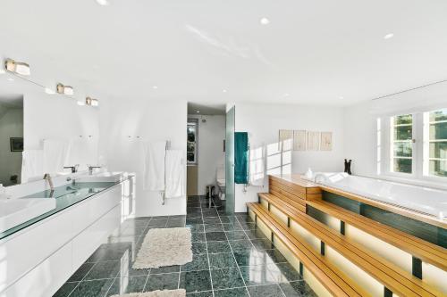 Solrød StrandDENMARK SEA FRONT ENCHANTING - Beach Villa的浴室配有2个盥洗盆、浴缸和2个盥洗盆。