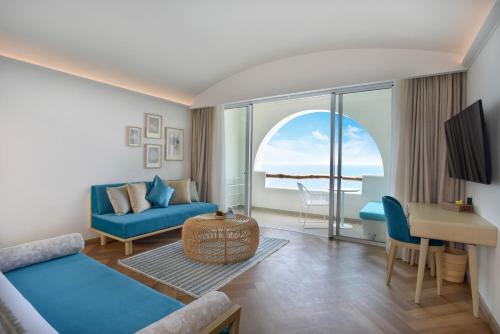 圣吉吉Royal Avila Boutique Resort的客厅配有蓝色的沙发和桌子