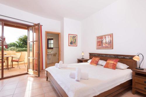 松霍里吉尔Villa Xoric by Villa Plus的一间带两张床的卧室和一个带桌子的阳台