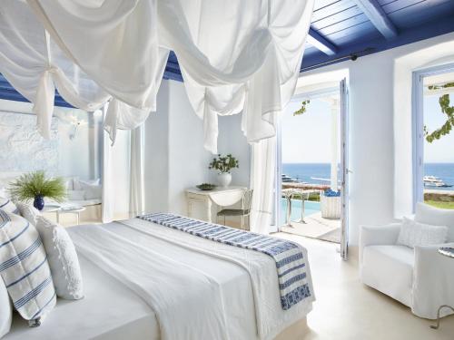 萨鲁Mykonos Blu, Grecotel Boutique Resort的一间白色的卧室,配有一张床,享有海景